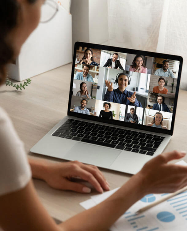 Person using a laptop in a video call with multiple participants
