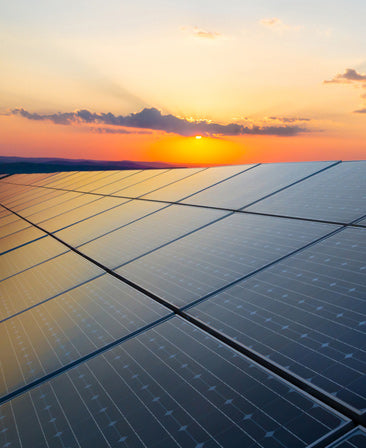 Solar panels with a sunset in the background
