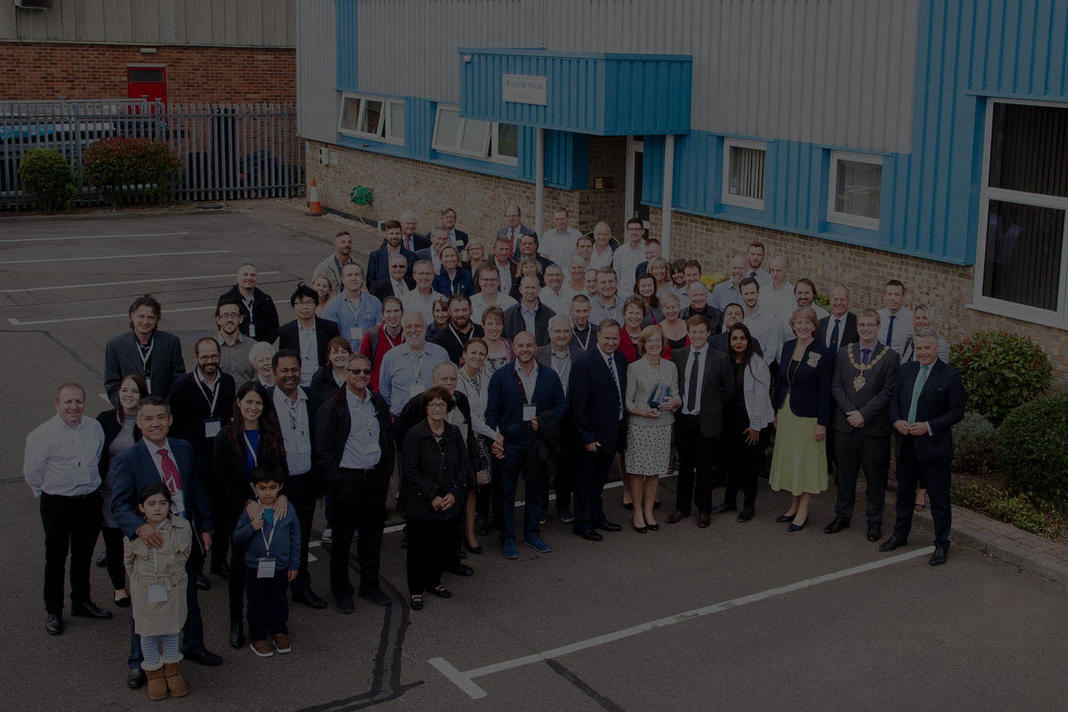 Group of ETI staff posing for a photo in front of a building