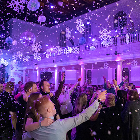 ETI staff celebrating indoors with purple lighting and snowflake decorations