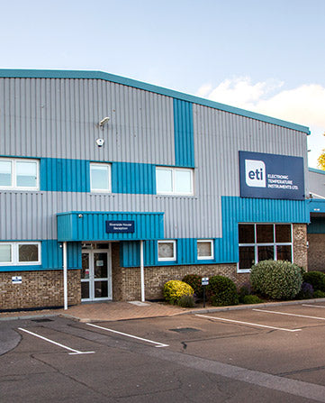 Factory building with blue and gray facade, featuring the ETI logo.