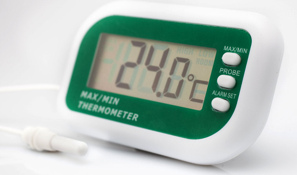 Digital thermometer with green display on a white background