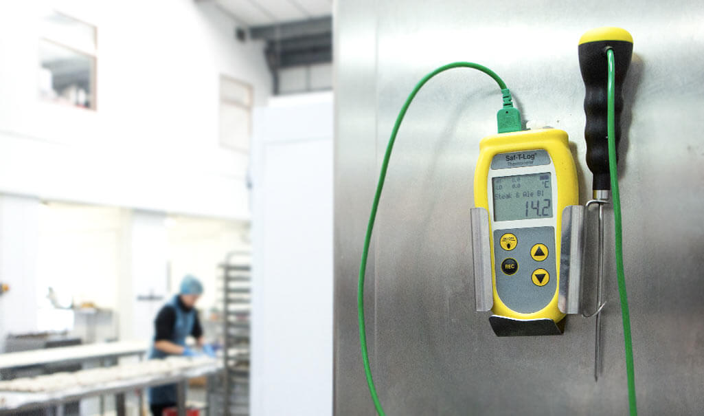Saf-T-Log thermometer attached to a metal door in a kitchen